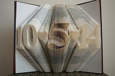 Pages of a book folded with a date separated by a heart